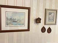 Overall view of framed Peter Robson print, cuckoo clock, fairy print, and two plaques on wall