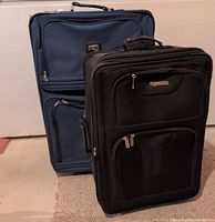 Blue Lynx suitcase and black Tracker suitcase side by side