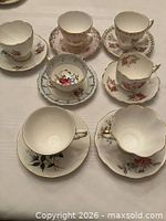 Group shot of all seven teacups and saucers on tabletop