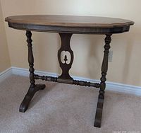 Front view of walnut lamp table showing legs and apron cut-out