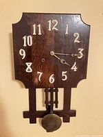 Front view showing full clock face with numerals and pendulum