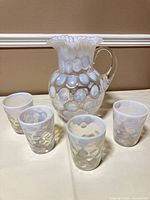 Pitcher front with four tumblers