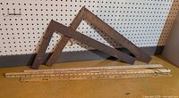 Overall lot showing two steel squares and three yardsticks