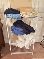 Full view rack with folded sheets and cream blanket