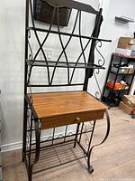 Full view of metal and wood baker's rack showing shelves, work surface, and drawer