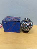 Urn, stand, and brocade box side by side