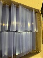 Open carton showing stacked clear PVC sign holder bases