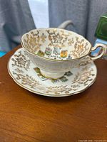 Teacup on saucer showing pattern and gold trim