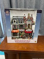 Front of boxed Carole Towne Village Hardware Store building