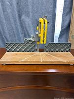 Full view of Craftsman miter box with yellow-frame saw on wood base