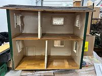 Front view of open-back dollhouse showing two stories and four rooms