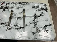 Five spring calipers laid out on surface