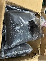 Inner plastic bags of black beard nets inside cardboard box