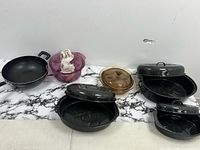 All items laid out: three roasters with lids, wok, mixing bowl, glass lid