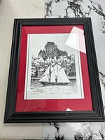 Entire framed print showing red mat and black frame