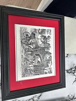 Framed artwork full view showing red mat and black frame