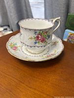 Teacup on saucer showing pattern and gold trim