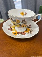 Teacup on saucer showing full floral pattern and gold trim