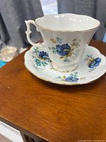 Teacup on saucer showing floral pattern and gold trim