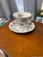 Teacup on saucer showing floral pattern and gold trim
