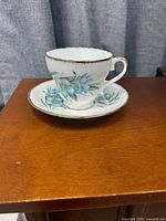 Teacup on saucer, front view showing pattern and gold trim