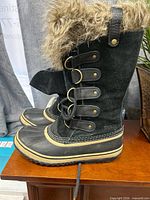 Side view of both boots showing overall style, materials, fur collar and closure