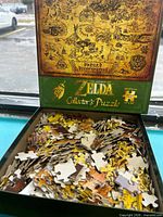 Open box showing loose puzzle pieces and inner lid artwork