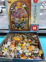 Open puzzle box with loose pieces and lid artwork visible