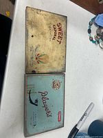 Both cigarette tins side by side to show overall condition and graphics