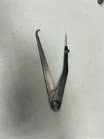 Full view of caliper with extended arms showing point and hook