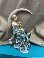 Full view of Wind Moon figurine showing fairy on crescent moon with cat and clouds