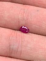 Ruby on fingertip showing size and oval faceting
