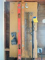 Full view showing both levels, chains, hook, bungees, holders on pegboard