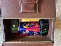 Overall view of interior of case showing shuffler box, bidding boxes and cards