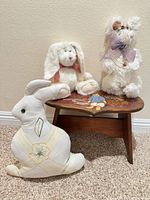 Stool and three stuffed rabbits arranged together