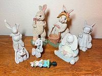Group shot of all seven rabbit figurines and bottle stopper