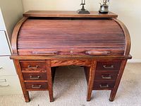 Full front view of oak roll-top desk with drawers and tambour closed