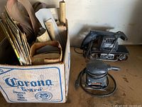 Overall lot showing box of sandpaper, Craftsman belt sander, Black & Decker sanding block