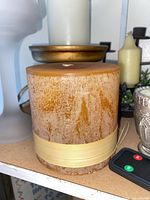 Large amber flameless candle, remote, surrounding candles and holders