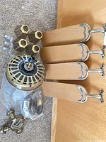 All fan components laid out: motor housing, 4 blades, 4 glass shades, light kit, hardware