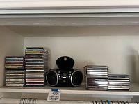 Shelved boombox flanked by two stacks of CDs