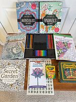 Overhead view of all coloring books, art supplies, case, crayons, tin