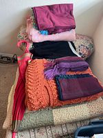 Stack showing blankets, scarves, umbrella and pants