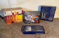 Four boxed sets of glassware displayed on carpet