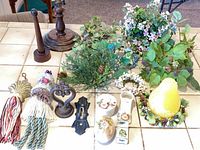 Group shot of all items including tassel tiebacks, wooden dowels, cast-iron pieces, porcelain miniatures, candle and greenery