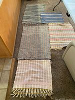 Overview of five rugs laid out on floor