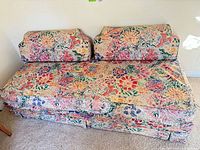 Front view of floral pull-out sofa bed with two back cushions