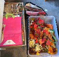Drawer of assorted paper gift bags next to bin of artificial foliage