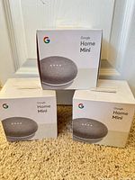 Front view of three Google Home Mini retail boxes