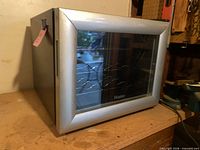 Front angled view of Haier wine cellar showing silver trim and glass door